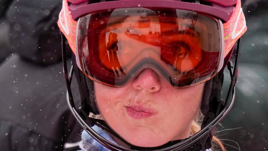 A close-up shot of a United States skier as she looks away through her ski googles after a run at the Winter Olympics. 
