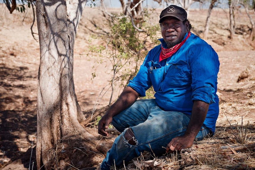 A photo of Indigenous man Matthew Algy sitting on country near Kalkarindji. Photo taken 8 August 2020.