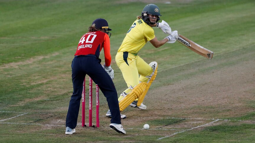 A cricketer runs the ball behind past the wicketkeeper in a Women's Ashes T20 match.