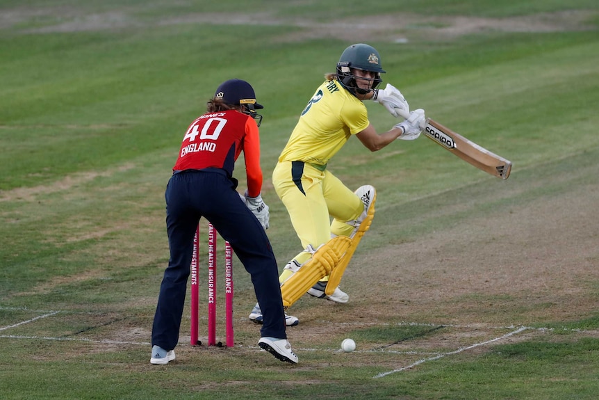 A cricketer runs the ball behind past the wicketkeeper in a Women's Ashes T20 match.