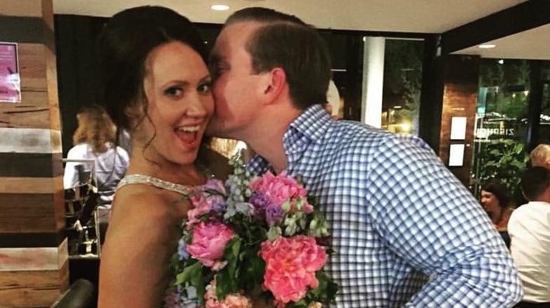 Melissa Laughlin with her partner, holding flowers