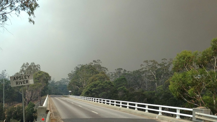 Smoke wafts over Coles Bay Road in Tasmania's north-east amid a fire emergency.
