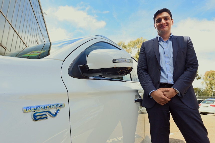 Behyad Jafari stands next to his car