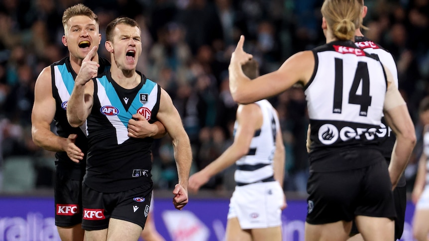 Robbie Gray puts his finger up in celebration as Ollie Wines hugs him from behind