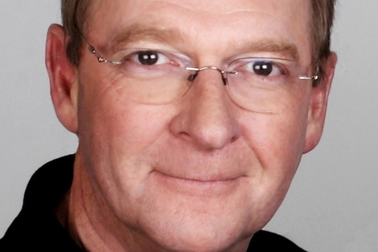 A headshot of Australian television and radio personality John Blackman
