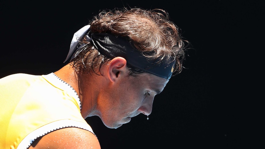 A man leans forward with sweat dripping off his nose