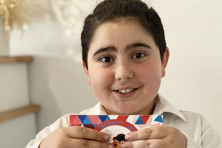 A boy smiling holding a certificate