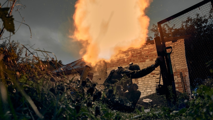 Soldiers take cover as a mortar fires