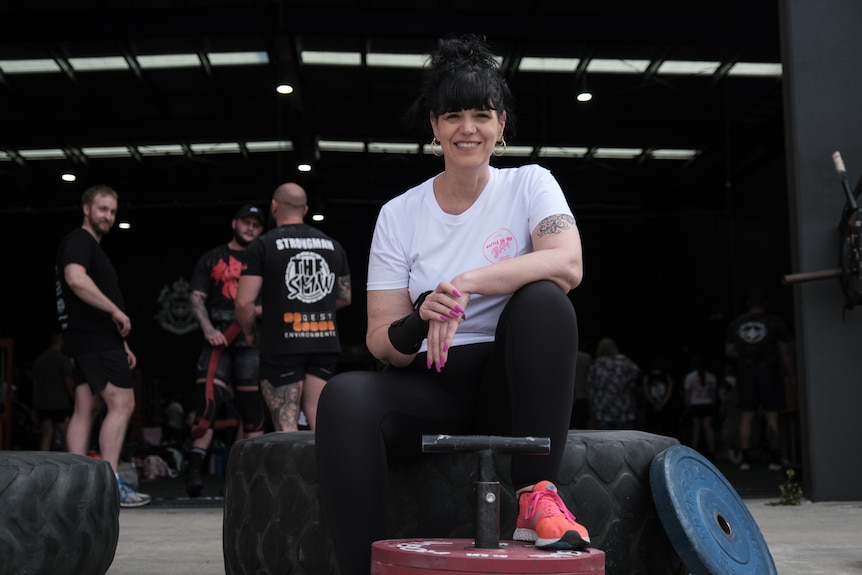 Justine Martin sits and smiles in a gym.