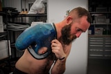 Team UK Invictus competitor Dan Richards strapping his prosthetic onto his shoulder.