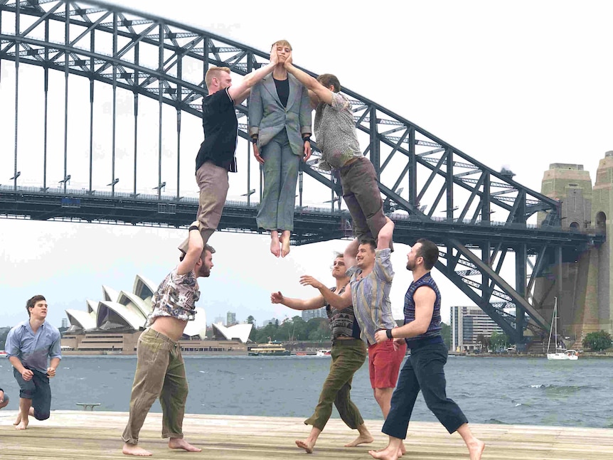 Mid-air acrobats in front of the bridge.