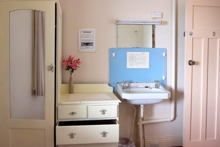 A run-down hotel room abandoned with draws left open.