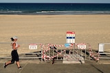 A jogger runs past closure signs at Sydney's Bondi Beach amid the coronavirus pandemic.