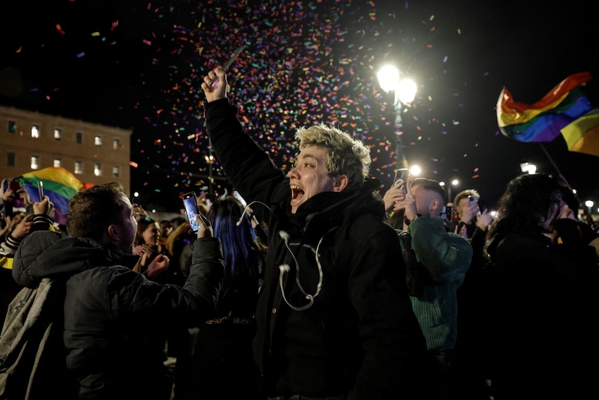 A supporter of the same-sex marriage bill celebrates its approval as confetti falls around her.