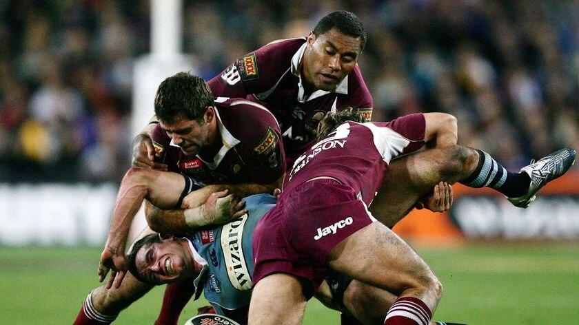 Danny Buderus is gang tackled by the Maroons defence