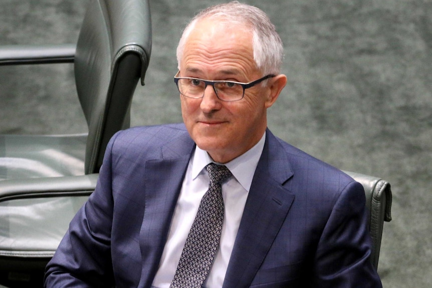 Malcolm Turnbull, sitting in the House of Representatives, looking up and smiling.