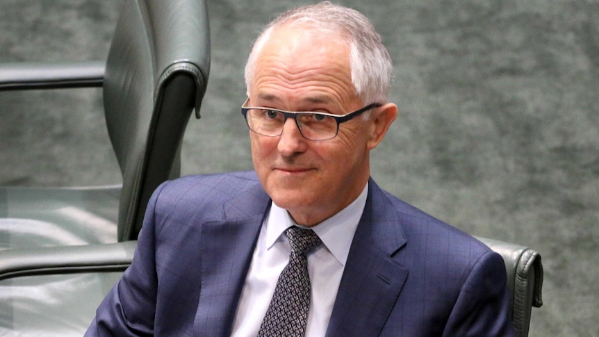 Malcolm Turnbull, sitting in the House of Representatives, looking up and smiling.