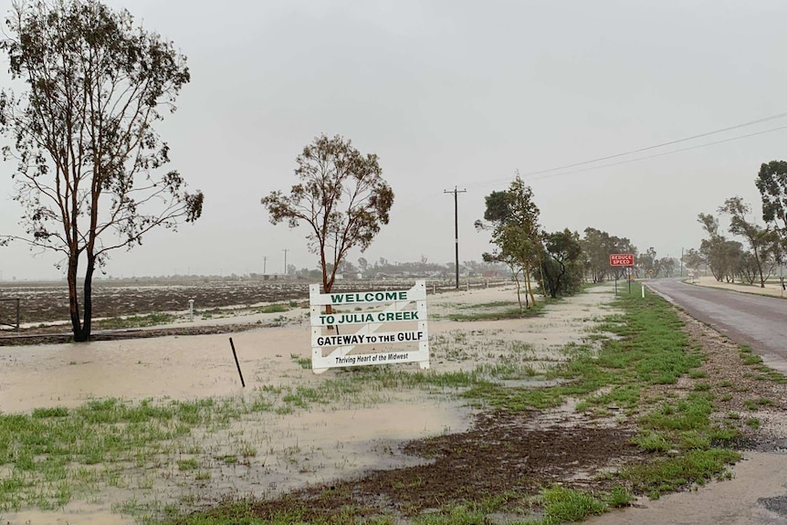 A welcome sign at Julia Creek in flood water after 230 millimetres of rain was recorded during the weather event.