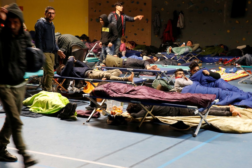 Asylum seekers sleep in a gym after evacuating from the Grande-Synthe refugee camp near Dunkirk.
