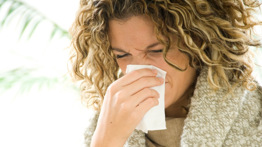 A woman blowing her nose.