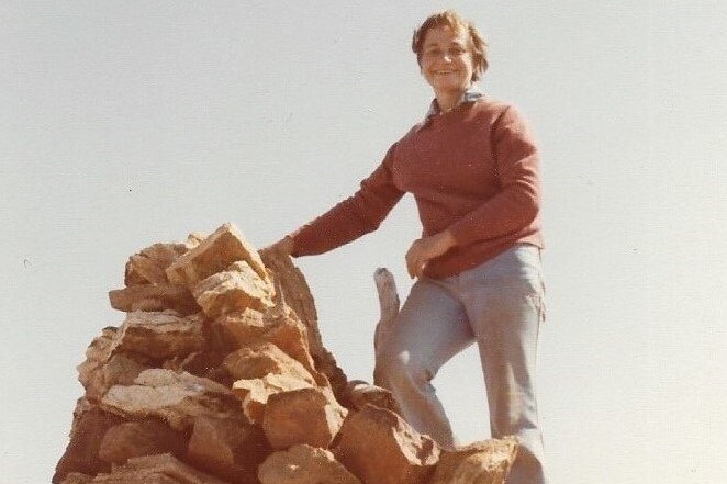 A woman stands on a rock