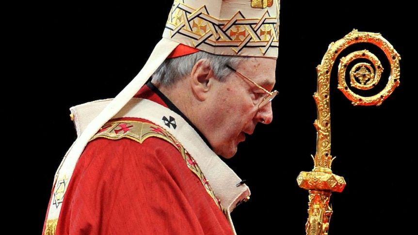 George Pell in full robes, holds a crook against a black background.