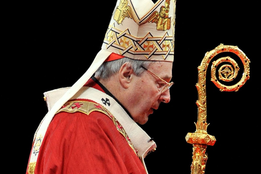 George Pell in full robes, holds a crook against a black background.