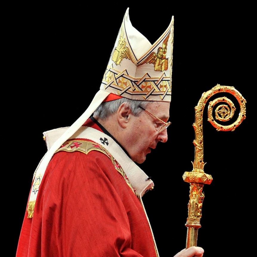 George Pell in full robes, holds a crook against a black background.