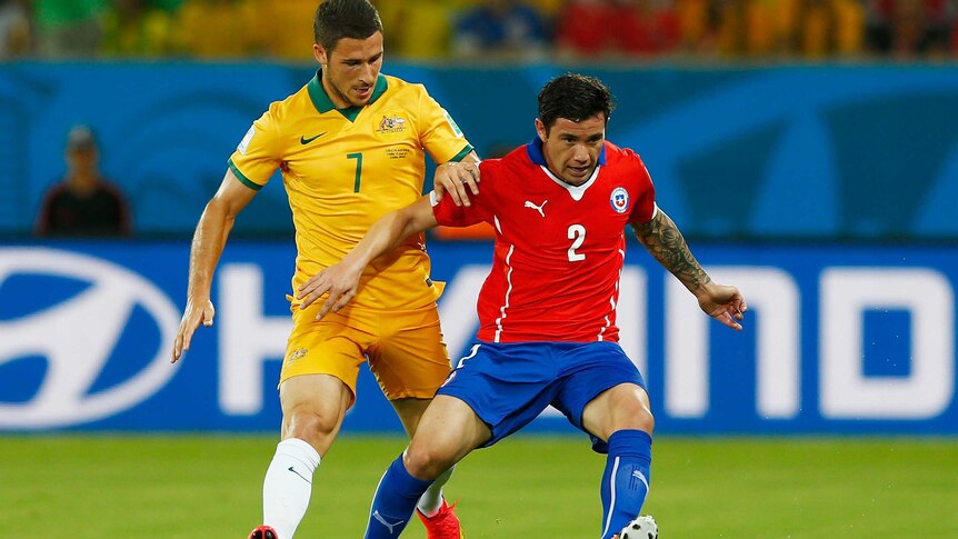 Socceroo Mathew Leckie challenges Chile's Eugenio Mena.