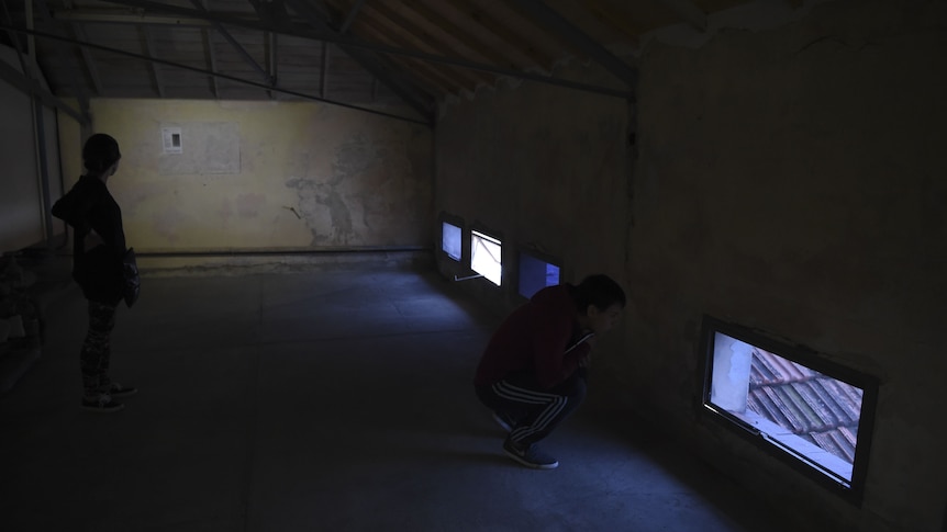 Two tourists visiting a former torture chamber at ESMA in Buenos Aires in 2016.