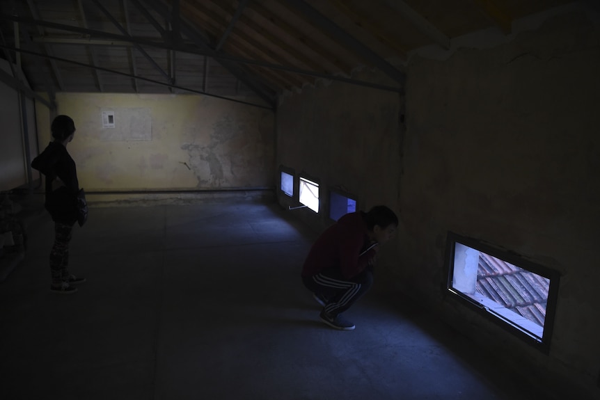 Two tourists visiting a former torture chamber at ESMA in Buenos Aires in 2016.