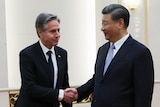 Antony Blinken shakes hands with Xi Jinping.