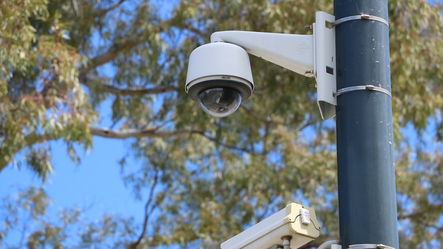 An outdoor security camera mounted on a pole. 