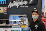 Naty heng wears a mask while standing in his empty burger shop in Fairfield.