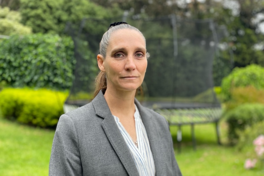 Donna-Louise Wilson stands in a garden and looks at the camera.