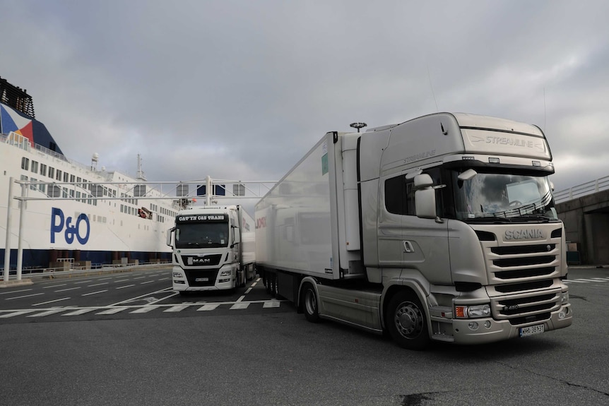 Two trucks with a large P&O ferry in the background.