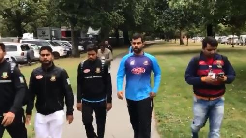 Several men in training gear walk quickly through a park in Christchurch.