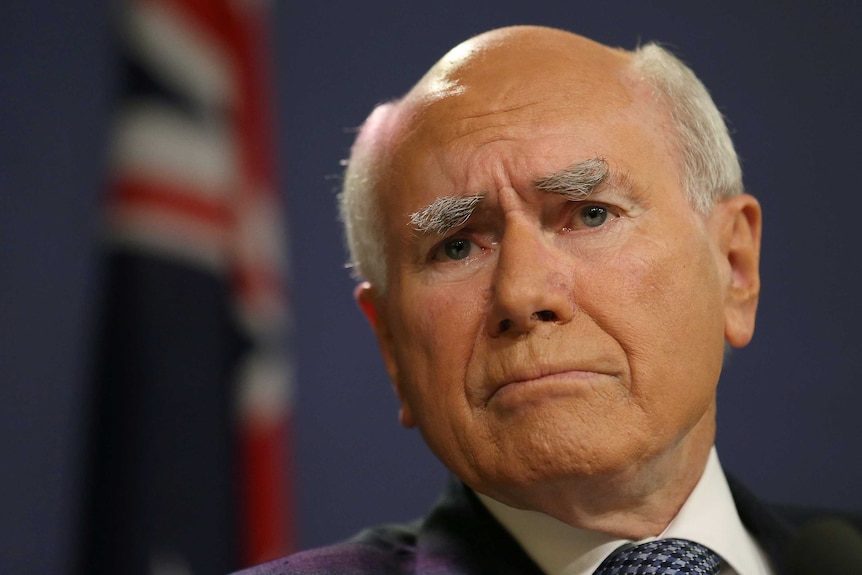 Former Australian prime minister John Howard gestures during a press conference