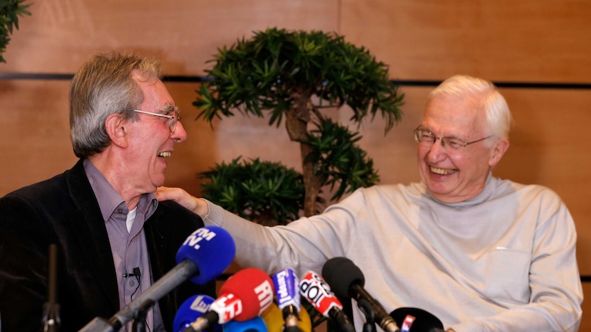 French scientist Jean-Pierre Sauvage reacts next to Jean-Marie Lehn