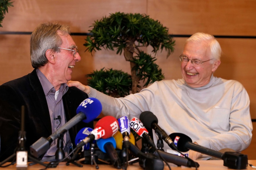 French scientist Jean-Pierre Sauvage reacts next to Jean-Marie Lehn