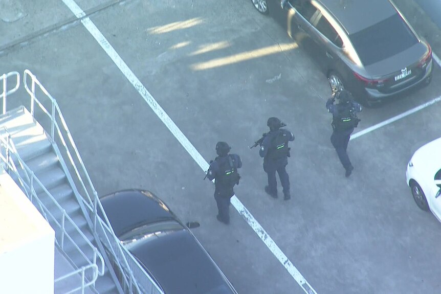 Agentes de policía realizan una búsqueda en el aparcamiento de un tejado de un centro comercial.