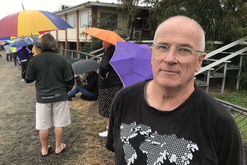 Gary waits in queue with wet glasses.