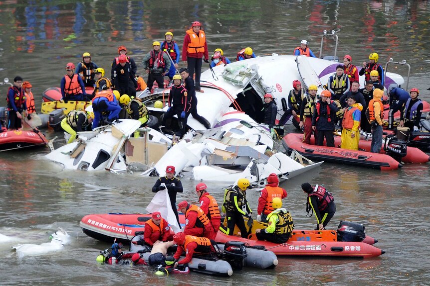 Taiwan rescue workers retrieve body from the wreckage of a TransAsia plane