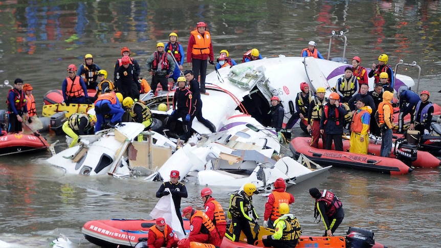 Taiwan rescue workers retrieve body from the wreckage of a TransAsia plane