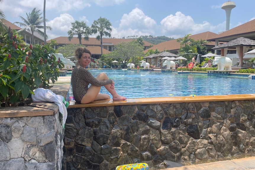 Eliza Hull sits on the edge of a pool at a holiday resort in Thailand.