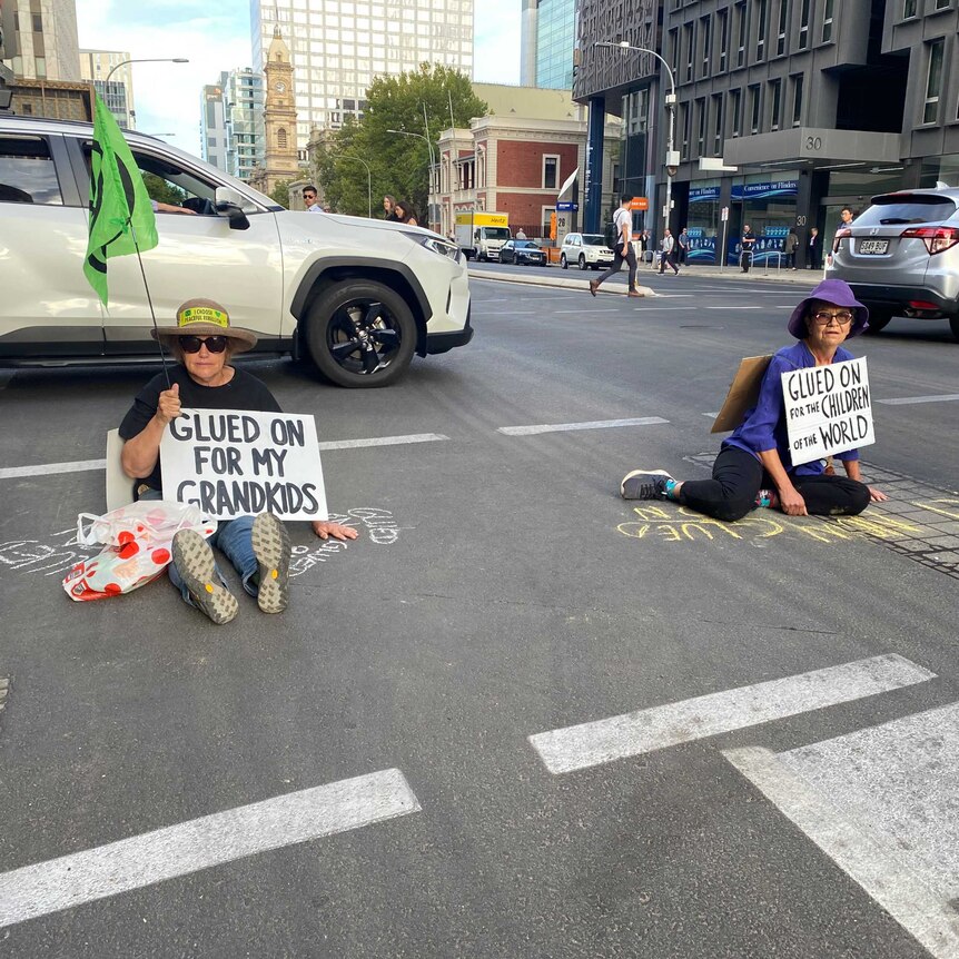 Two protesters sitting on Flinders Street