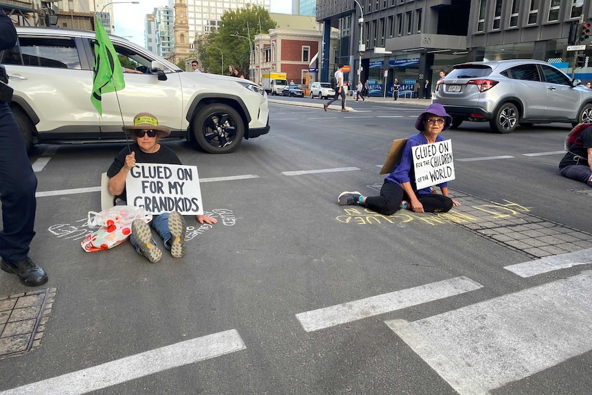 Two protesters sitting on Flinders Street