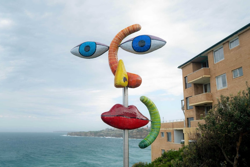 Sculpture “The Face” by Deborah Halpern features colourful facial features.