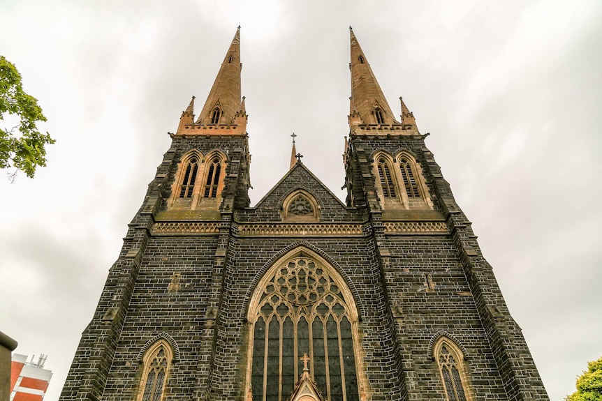 The facade of St Patrick's Cathedral reaches into a cloudy sky.