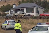 Police outside a house at Hamilton, Tasmania, where two people were shot dead in front of a 9-year-old girl.